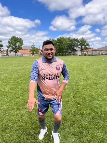 Erick Castañeda, centrocampista de La Calle Maldita, con el uniforme salmón del equipo en una cancha de pasto