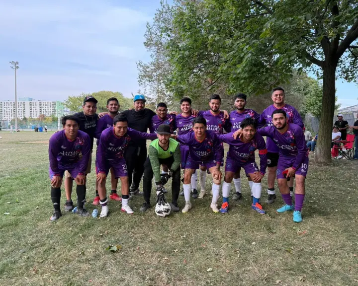 El equipo de La Calle Maldita con el uniforme morado, en una cancha de pasto de Toronto en verano